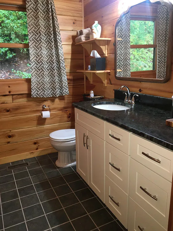 Antique white shaker vanity cabinet in rustic bathroom