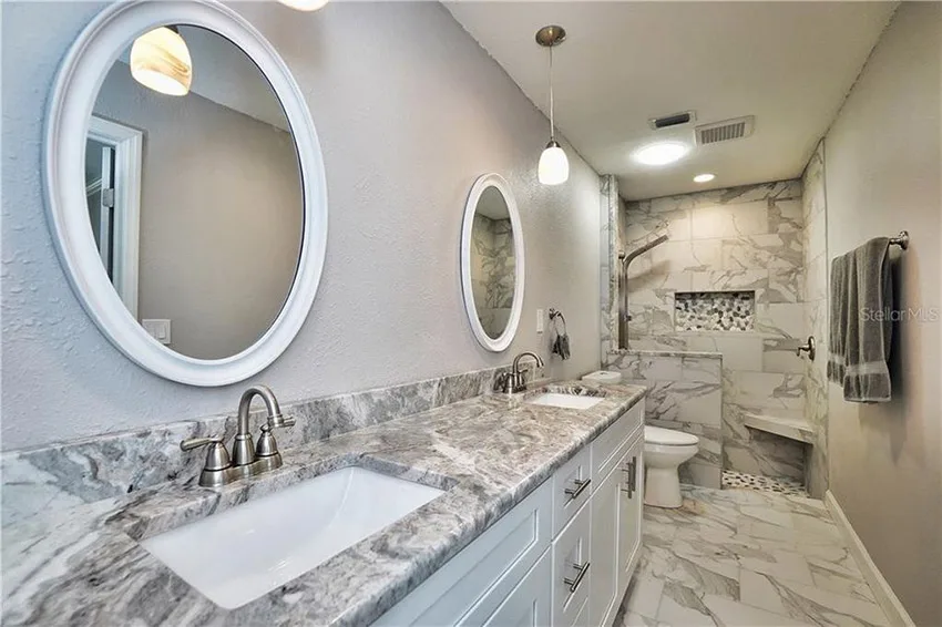 White shaker bathroom vanity with marble countertop after refinishing