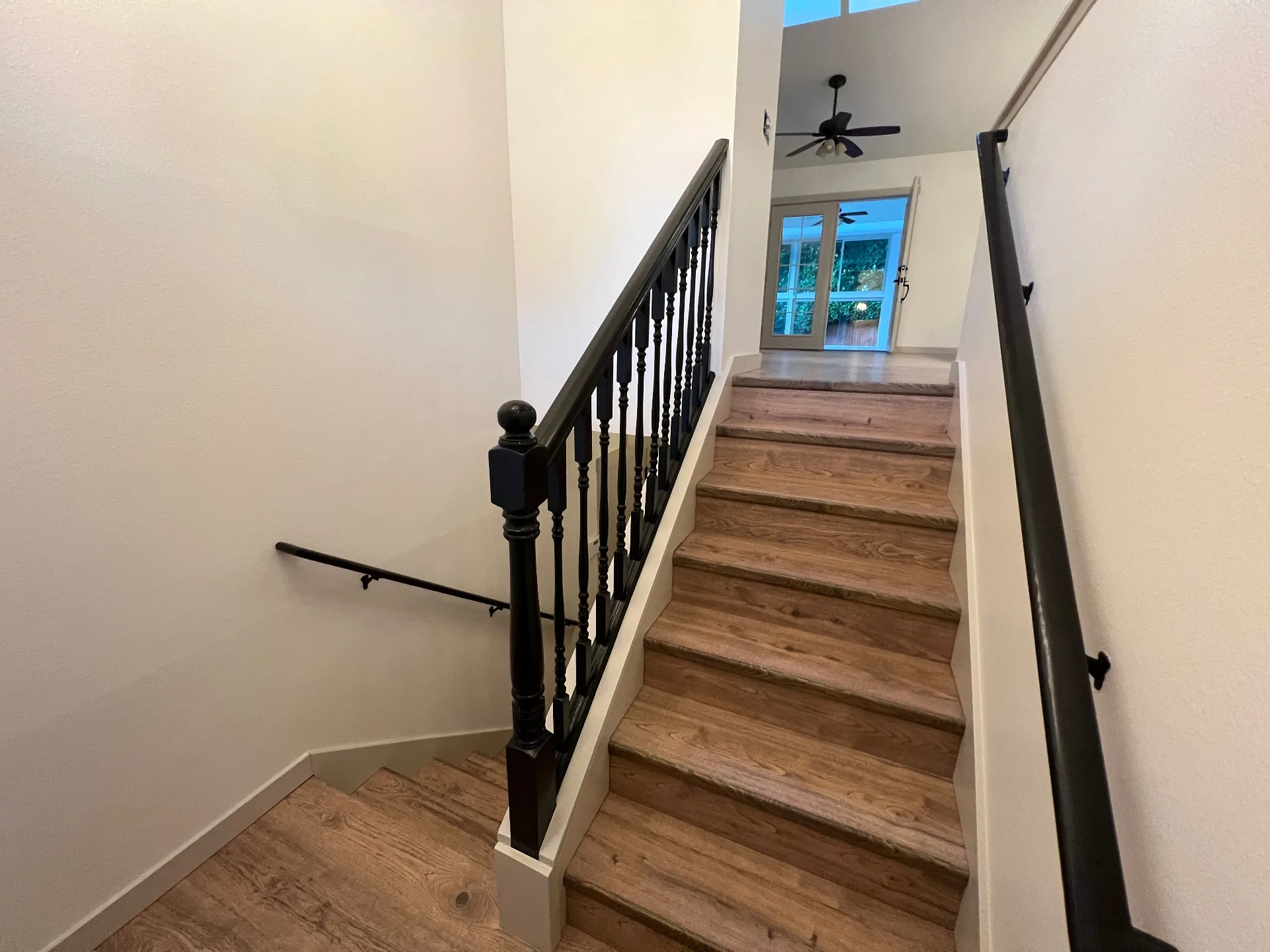 Freshly painted entryway and staircase with dark railing