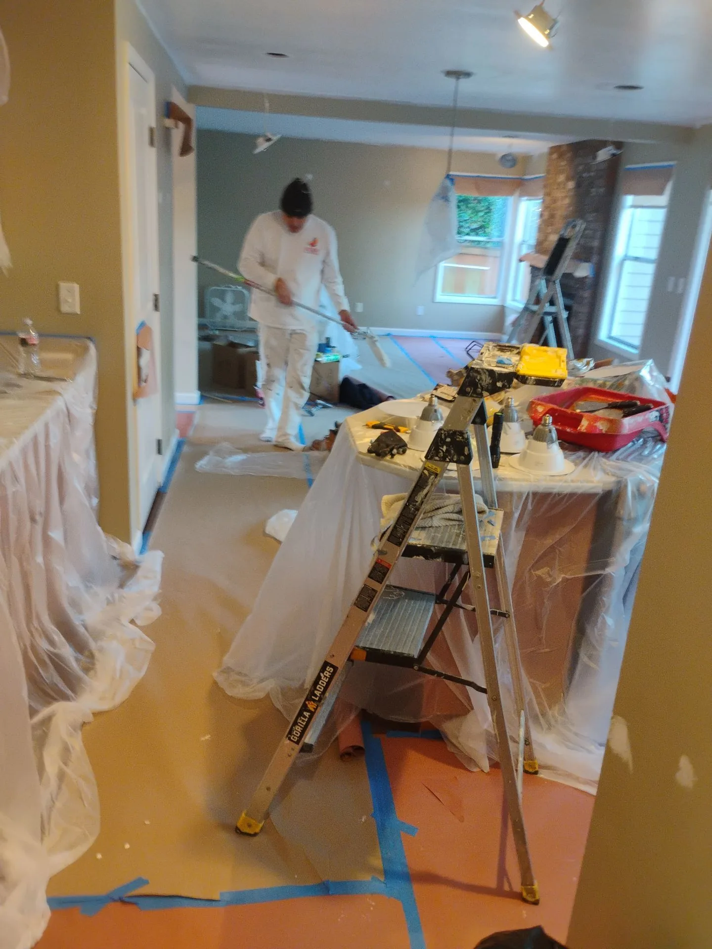Interior painting in progress with protective coverings